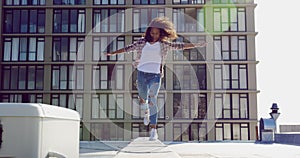 Fashionable young woman on urban rooftop balancing