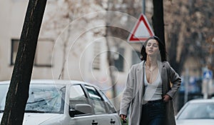 Fashionable young woman walking confidently on urban street photo