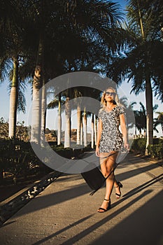 Fashionable young woman walking through Mexico with Palm Trees