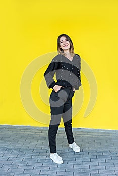 fashional portrait of pretty lady near yellow wall