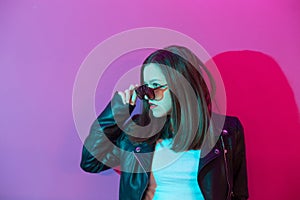 Fashioned girl in leather jacket in dark glasses