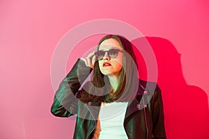 Fashioned girl in leather jacket in dark glasses