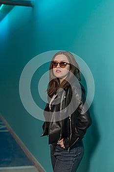 Fashioned girl in leather jacket in dark glasses