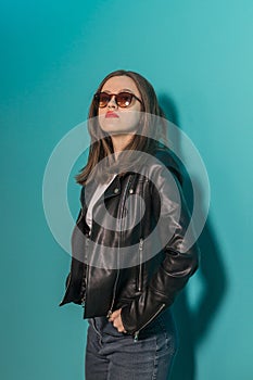 Fashioned girl in leather jacket in dark glasses