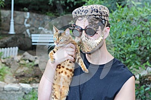 Fashionista holding a cat while wearing golden mask