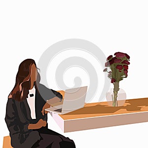 Fasion girl sitting alone with laptop and working. Vase with flowers on the table