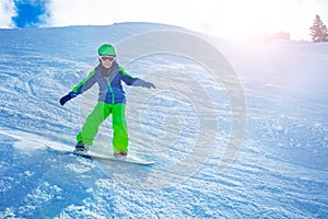 Fast action photo of boy go downhill on snowboard