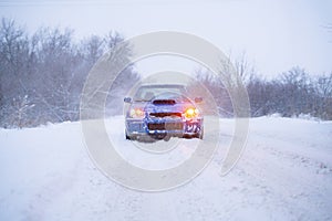 a fast blue sport car on winter snowy day, cold season, street road