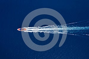 Fast boat at the sea in Bali, Indonesia. Aerial view of luxury floating boat on transparent turquoise water at sunny day. Top view