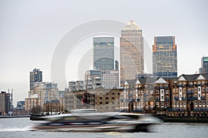 Fast boat on Thames, London; Canary Wharf at back