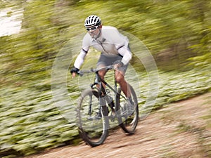 Fast, cycling and man on a bike in nature for fitness, sports or a competition. Energy, mountains and a male cyclist on