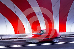 Fast driving car in tunnel with red stripes