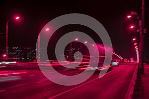 Fast driving traffic at night. Abstract blurred background of urban moving cars with bright brake lights at night. Auto, city