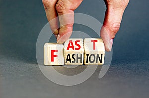 Fast fashion symbol. Concept words Fast fashion on wooden cubes. Beautiful grey table grey background. Businessman hand. Business