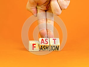 Fast fashion symbol. Concept words Fast fashion on wooden cubes. Beautiful orange table orange background. Businessman hand.