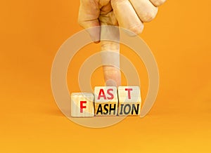 Fast fashion symbol. Concept words Fast fashion on wooden cubes. Beautiful orange table orange background. Businessman hand.