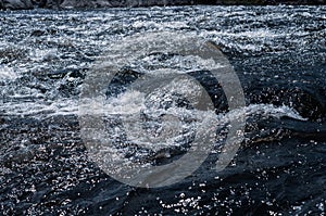 Fast flowing cold water mountain stream, flowing stormy stream stream, nature outdoors, fresh stream dark blue water