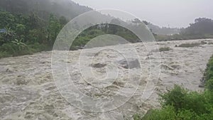 Fast flowing stream run down among the rocks in tropical rain forest. Overwhelm flash flood make damages along waterways.