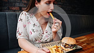 Fast food burger eat. Pretty Young Happy Woman Eating Tasty Hamburger. Junk Food Concept.