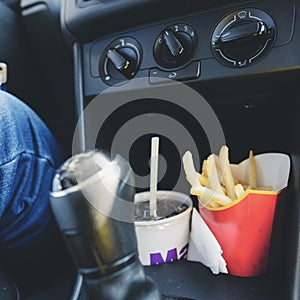 Fast Food in a car: cold beverage and delicious French fries, to