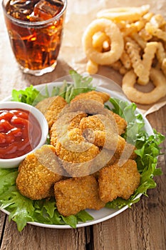 Fast food chicken nuggets with ketchup, french fries, cola