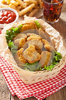 Fast food chicken nuggets with ketchup, french fries, cola