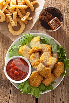 Fast food chicken nuggets with ketchup, french fries, cola