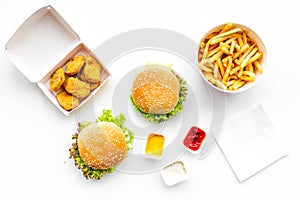 Fast food. Chiken nuggets, burgers and french fries on white background top view