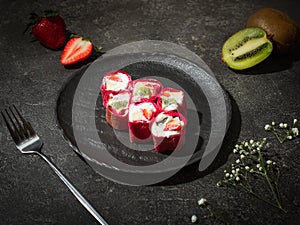 Fast food collection. Rolls with strawberries and kiwi on a dark background.