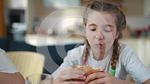 fast food concept. delicious breakfast unhealthy food concept. children girls eat hamburgers and drink cola in the