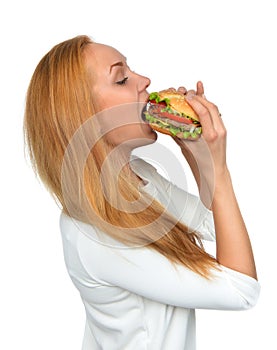 Fast food concept. Woman eating tasty unhealthy burger sandwich