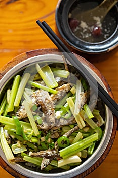 fast food of deep fried little fishes and celery with bowl of soup vertical composition