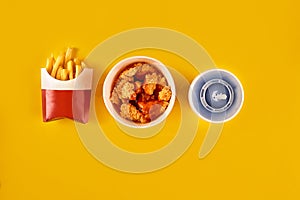 Fast food dish on yellow background. Fast food set fried chicken and french fries. Take away fast food.