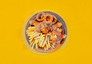 Fast food dish on yellow background. Fast food set fried chicken and french fries. Take away fast food.