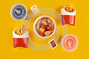 Fast food dish on yellow background. Fast food set fried chicken and french fries. Take away fast food.