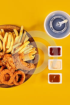 Fast food dish on yellow background. Fast food set fried chicken and french fries. Take away fast food.