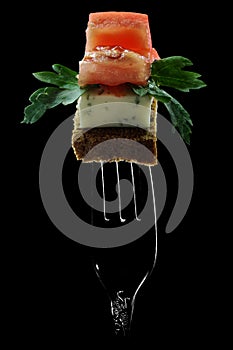 fast food on a fork, appetizer for spirits, sire on grain bread with herbs and tomato,