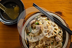 fast food of fried pork with slices of lotus root with bowl of soup horizontal composition