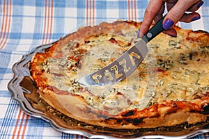 Fast food. Lady preparing to cut pizza, close-up