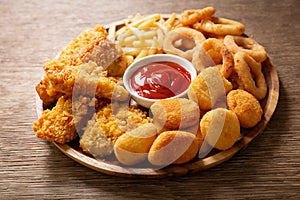 Fast food meals : onion rings, french fries, chicken nuggets and fried chicken