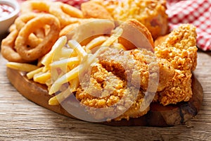 Fast food meals : onion rings, french fries, chicken nuggets and fried chicken