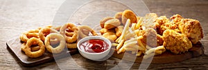 Fast food meals : onion rings, french fries, chicken nuggets and fried chicken