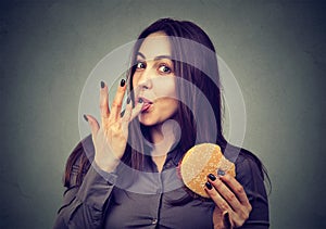 Fast food is my favorite. Woman eating a hamburger enjoying the taste