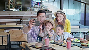 Fast food party, cheerful family cheerful parents loving mom and dad with male children enjoy rest in restaurant or cafe