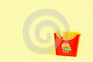 fast food. plastic french fries on a yellow background