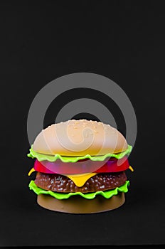 Fast food. plastic hamburger on a black background