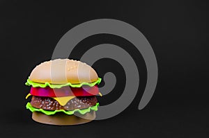 Fast food. plastic hamburger on a black background