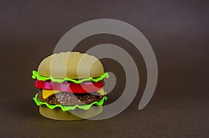 Fast food. plastic hamburger on a brown background