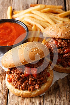 Fast food: sandwich Sloppy Joe with tomato sauce and fries close