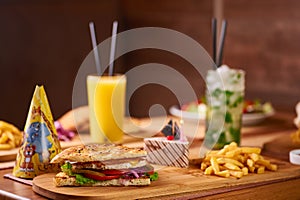 Fast food served table for company of friends. burger, french fries at birthday served table